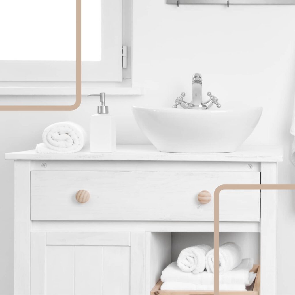 A white bathroom cabinet with a white sink and rolled white towels